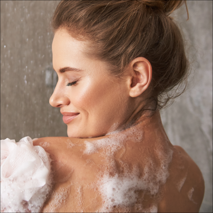 woman showering with body wash for acne
